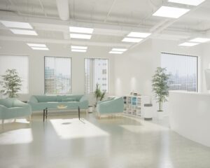Moderne, lichte wachtruimte met mintgroene stoelen, grote ramen en kamerplanten.