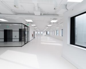 Licht en modern leeg kantoorpand met grote ramen en glazen binnenwanden.