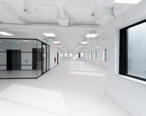 Licht en modern leeg kantoorpand met grote ramen en glazen binnenwanden.