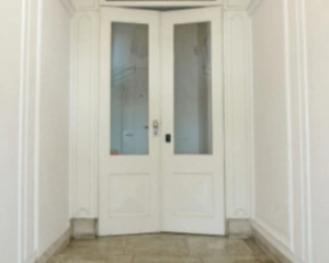 Witte dubbele binnendeur met glazen panelen in een lichtgekleurde gang.