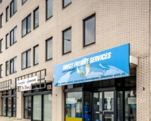 Voorgevel van een bedrijfsgebouw met het bord "Direct Freight Services" in Dordrecht.
