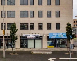 Voorgevel van een kantoorpand met de ingangen van Evangelie Gemeente De Deur en Direct Freight Service.