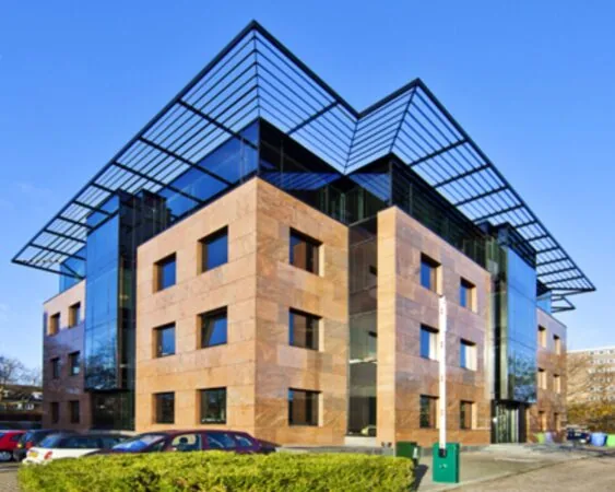 Modern kantoorgebouw met glazen accenten en een opvallend metalen dakraster.