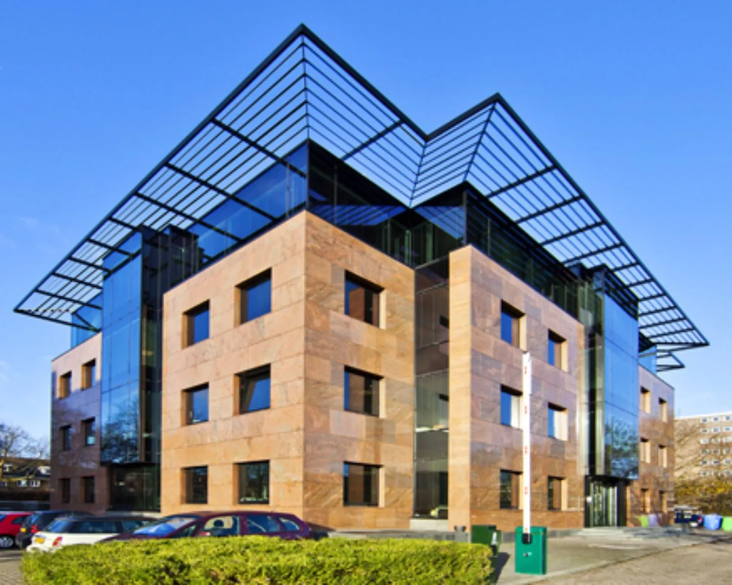 Modern kantoorgebouw met glazen accenten en een opvallend metalen dakraster.