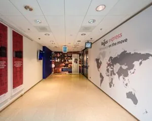 Geverfd kantoorinterieur van Regus Express met wereldkaart en de tekst "workspace on the move" op de muur.