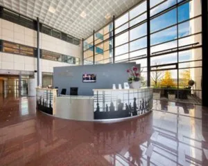 Moderne receptiebalie in de lobby van een Regus-kantoor met grote ramen en veel natuurlijk licht.
