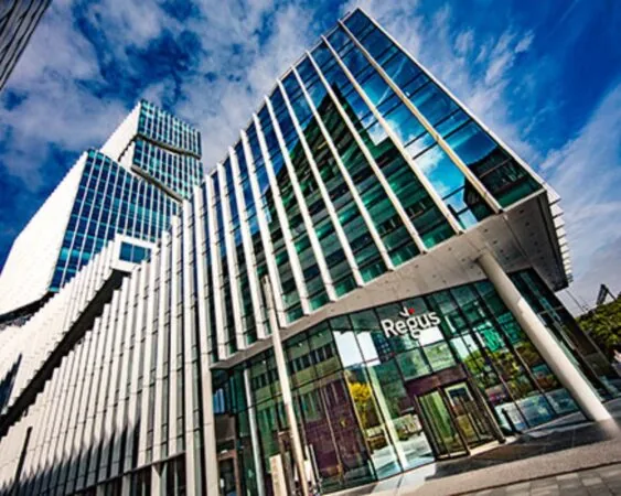 Modern glazen kantoorgebouw van Regus onder een blauwe lucht.