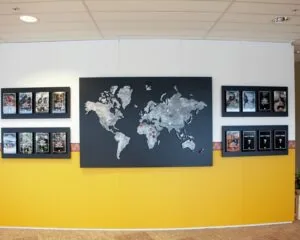 Wanddisplay met een wereldkaart en omliggende posters van televisieprogramma’s over stammen wereldwijd.