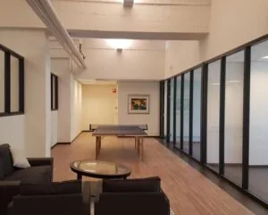 Moderne kantoorruimte met een zithoek en een pingpongtafel in het midden van de ruimte.