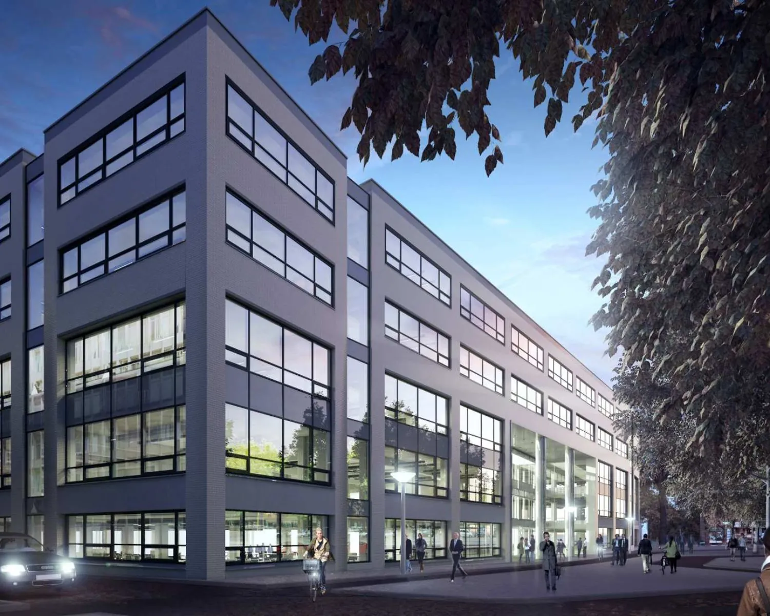 Modern kantoorgebouw met grote ramen en meerdere verdiepingen, omgeven door voetgangers en bomen in de schemering.