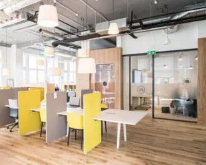 Moderne, open kantoorruimte met flexibele werkplekken en vergaderruimtes met glazen wanden.