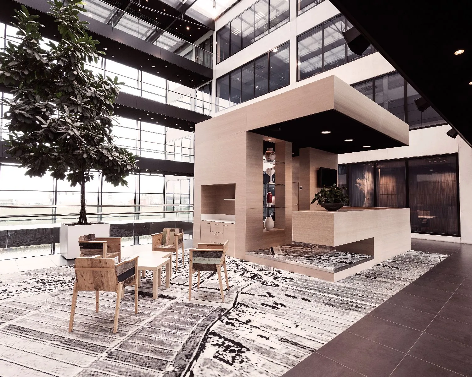 Moderne kantoorlobby met houten receptiemeubel, designstoelen, kunstige vloerkleden en een grote binnenboom.
