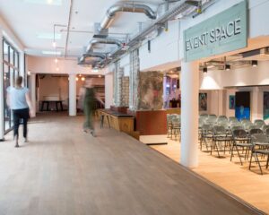 Moderne binnenruimte met industriële uitstraling en opstelling van stoelen in een zaal gemarkeerd als "Event Space".