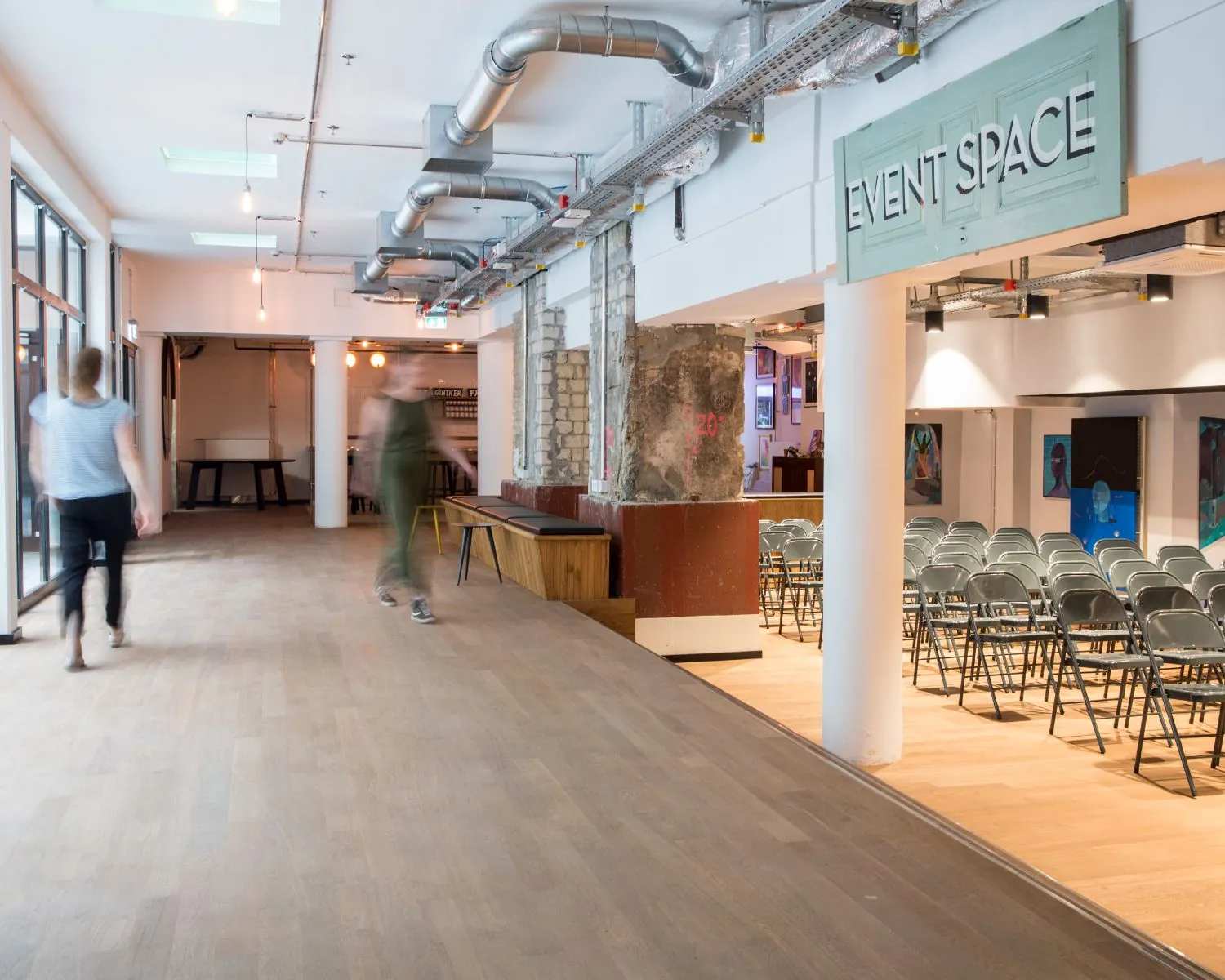 Moderne binnenruimte met industriële uitstraling en opstelling van stoelen in een zaal gemarkeerd als "Event Space".