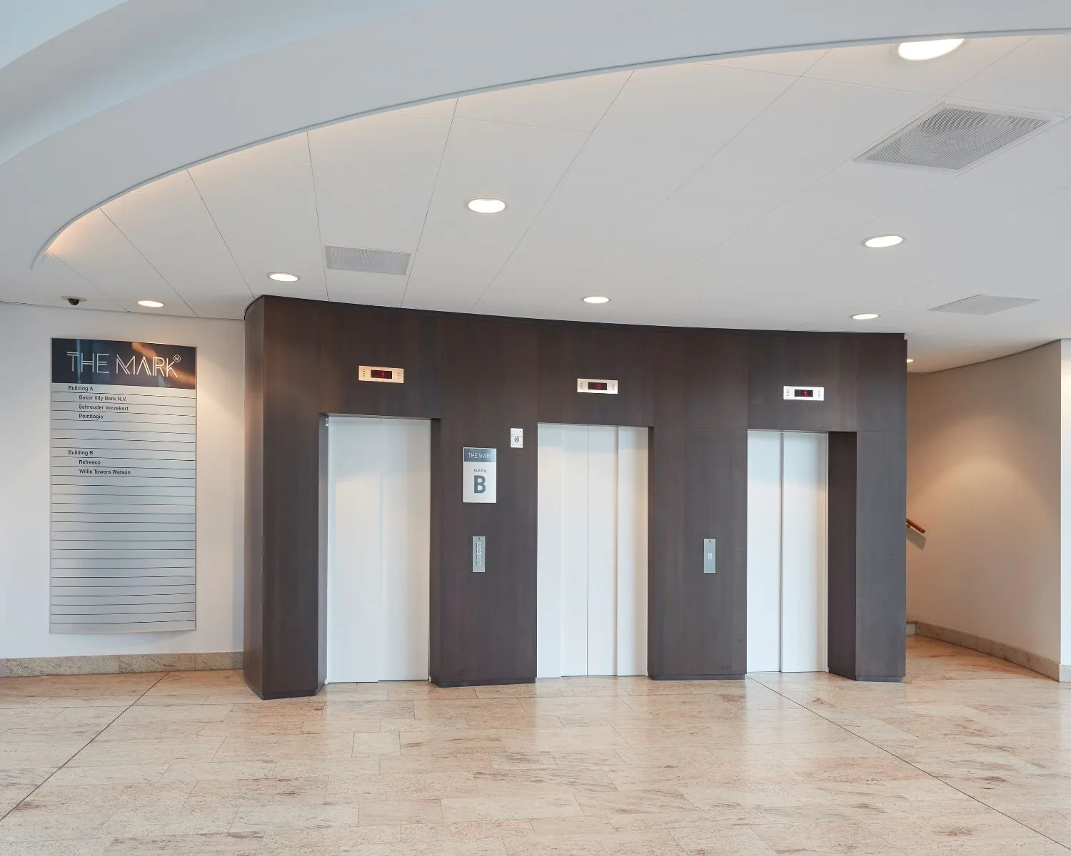 Drie gesloten liften in een moderne hal van kantoorgebouw The Mark.