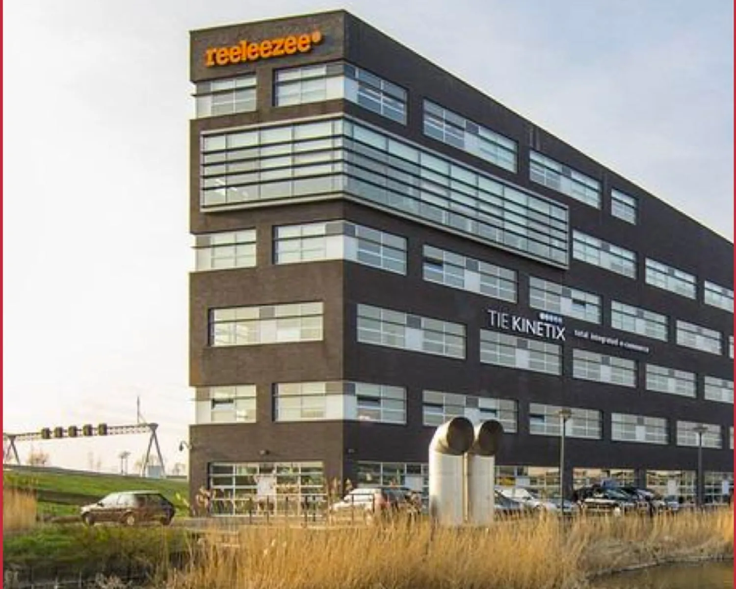 Modern kantoorgebouw met de logo's van Reeleezee en TIE Kinetix aan de gevel.