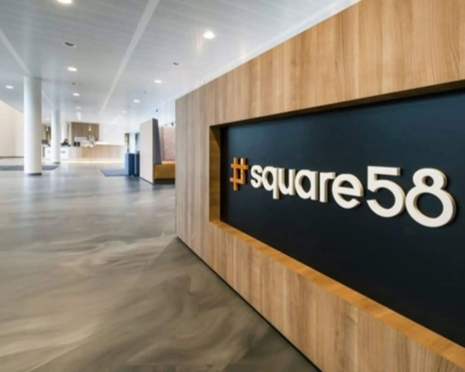 Moderne kantoorruimte met houten accenten en een wand met het logo van square58.