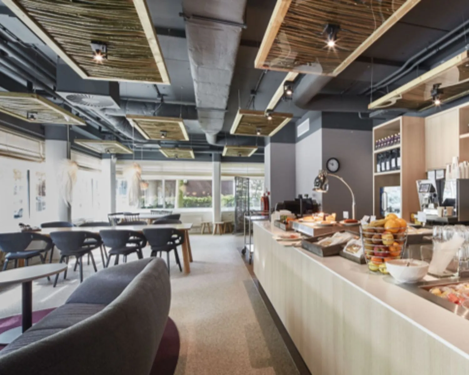 Moderne en lichte ontbijtruimte met zelfbedieningsbuffet en zitgedeelte in een hotel of café.