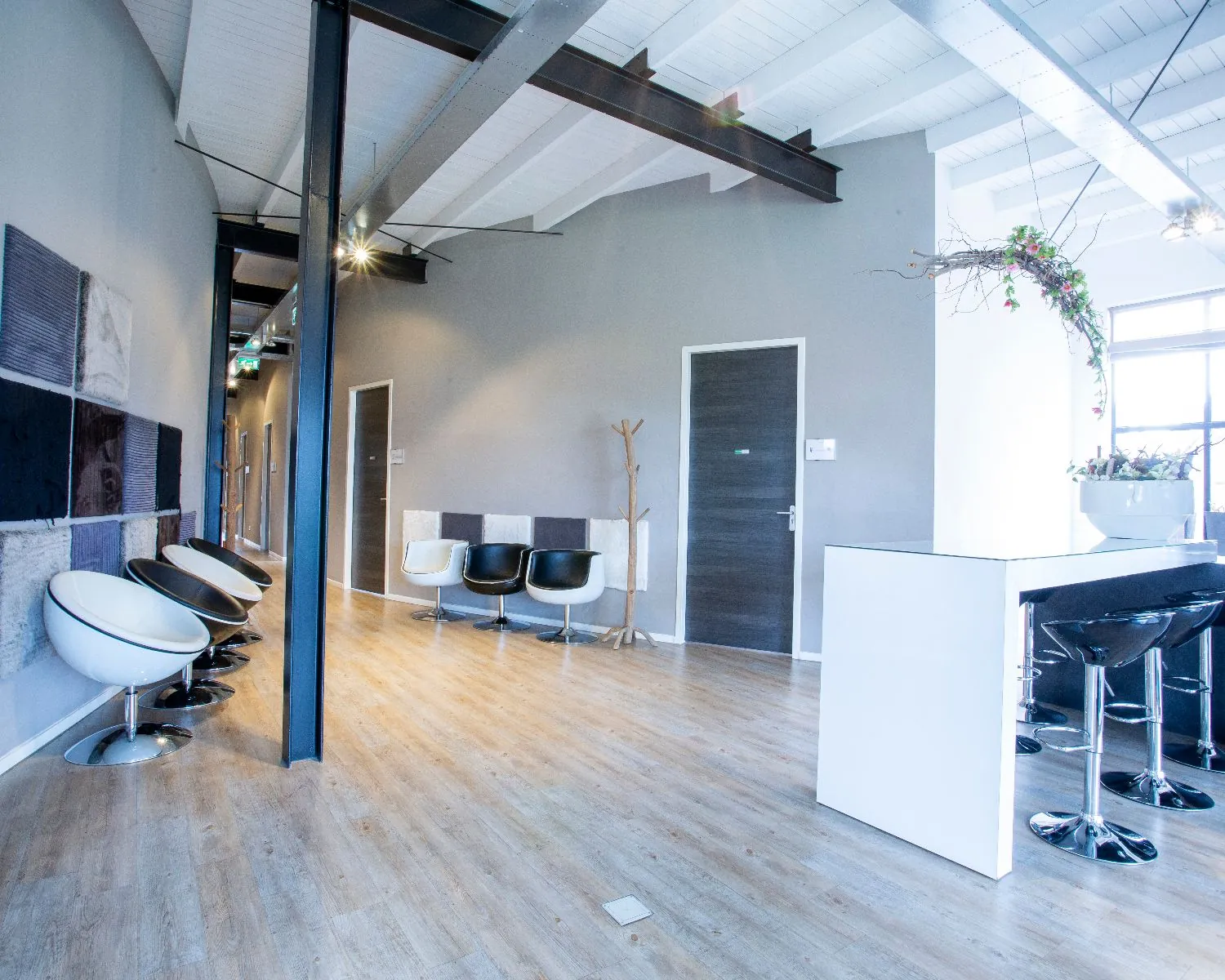 Moderne wachtruimte met designstoelen, houten vloer en een minimalistisch interieur.