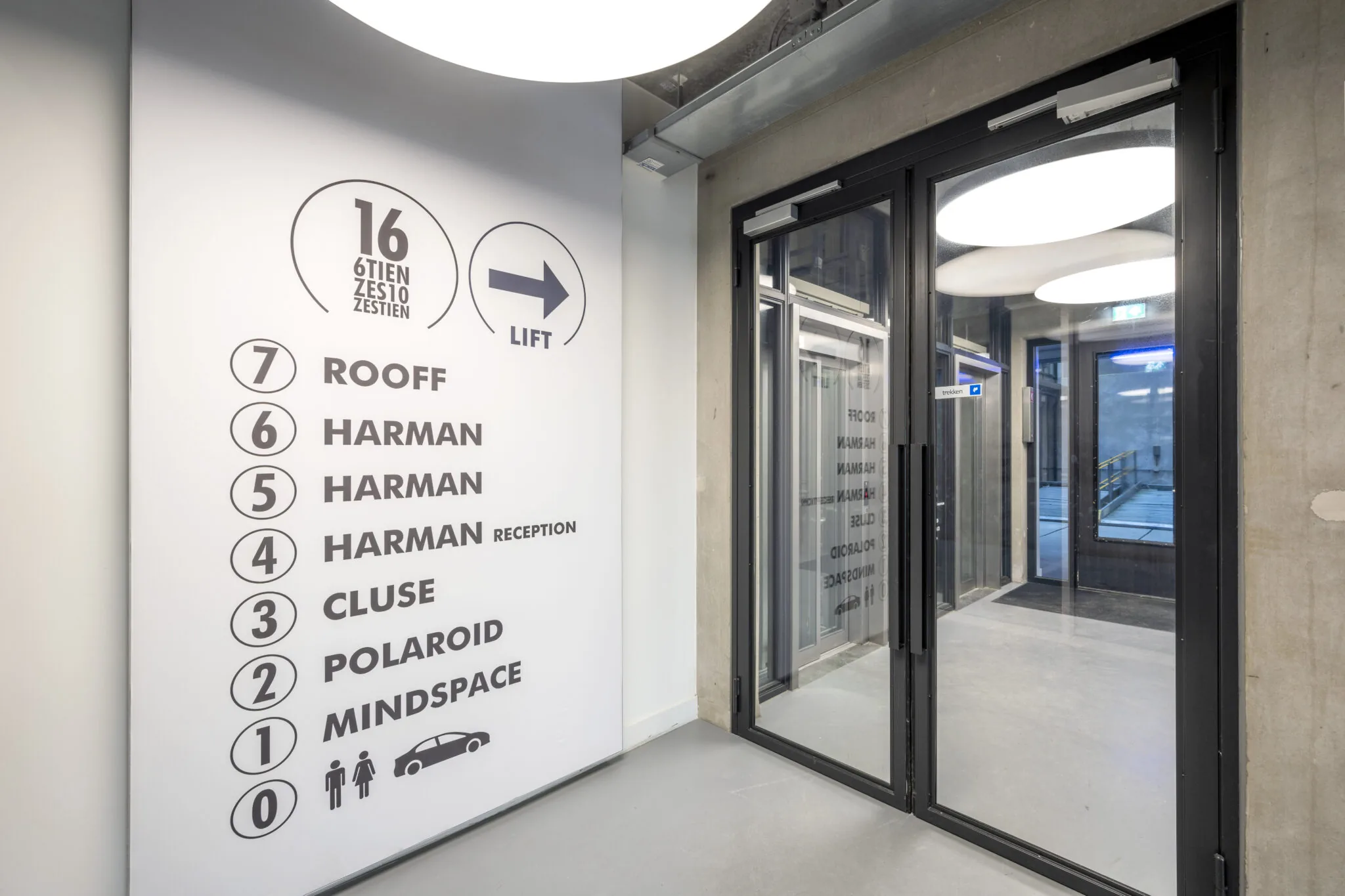 Ingang met overzichtsbord van bedrijven op verschillende verdiepingen in het gebouw aan de Danzigerkade.