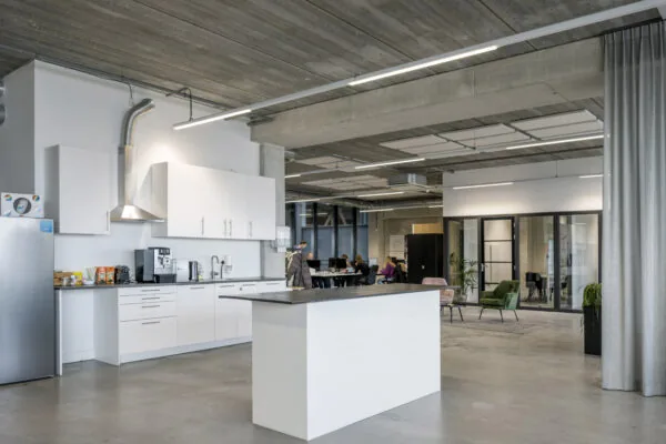 Moderne kantoorruimte aan de Danzigerkade met open keuken en gezamenlijke werkplek.