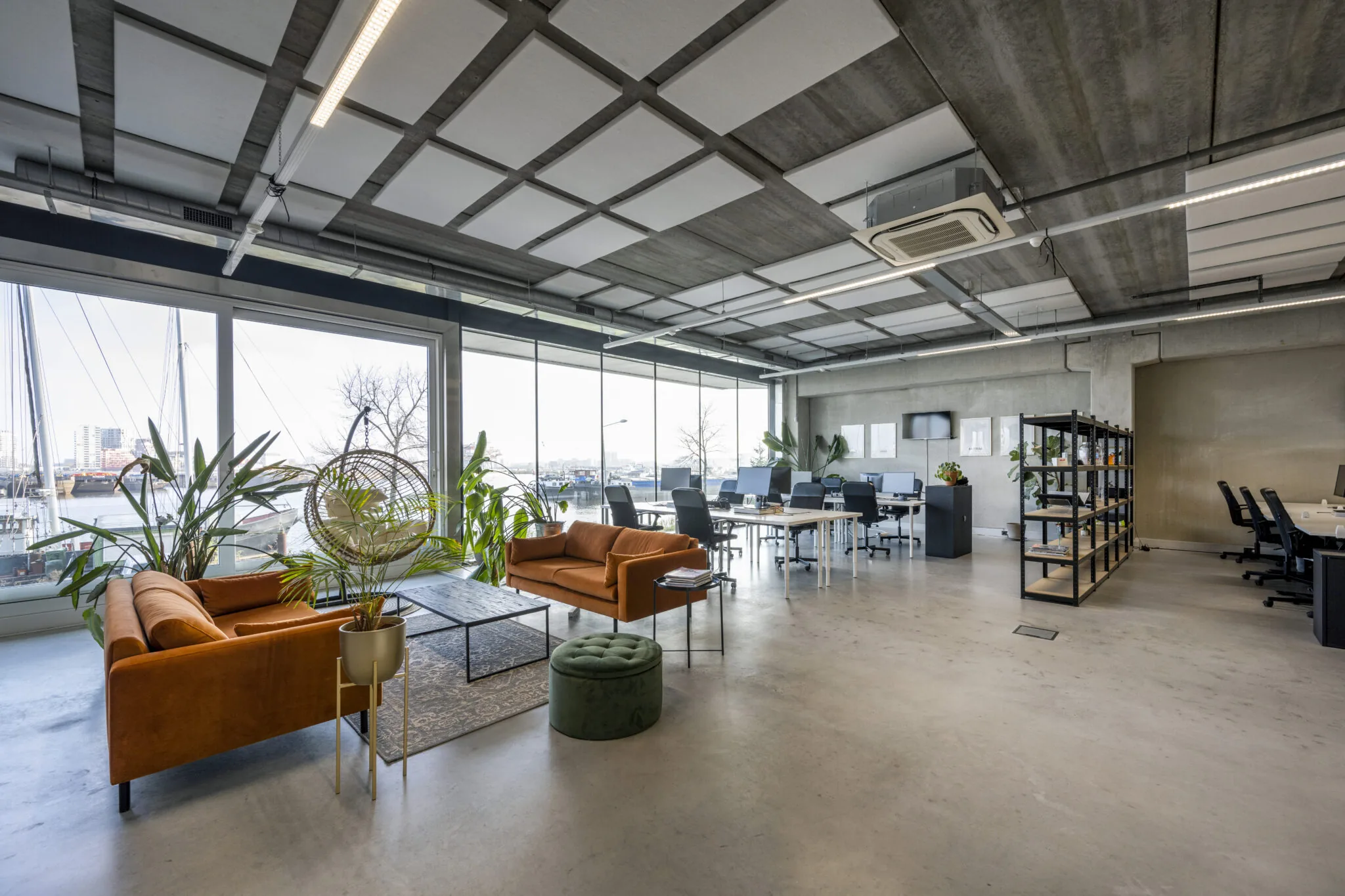 Moderne kantoorruimte op de Danzigerkade met open werkplekken, zithoeken en uitzicht op het water.