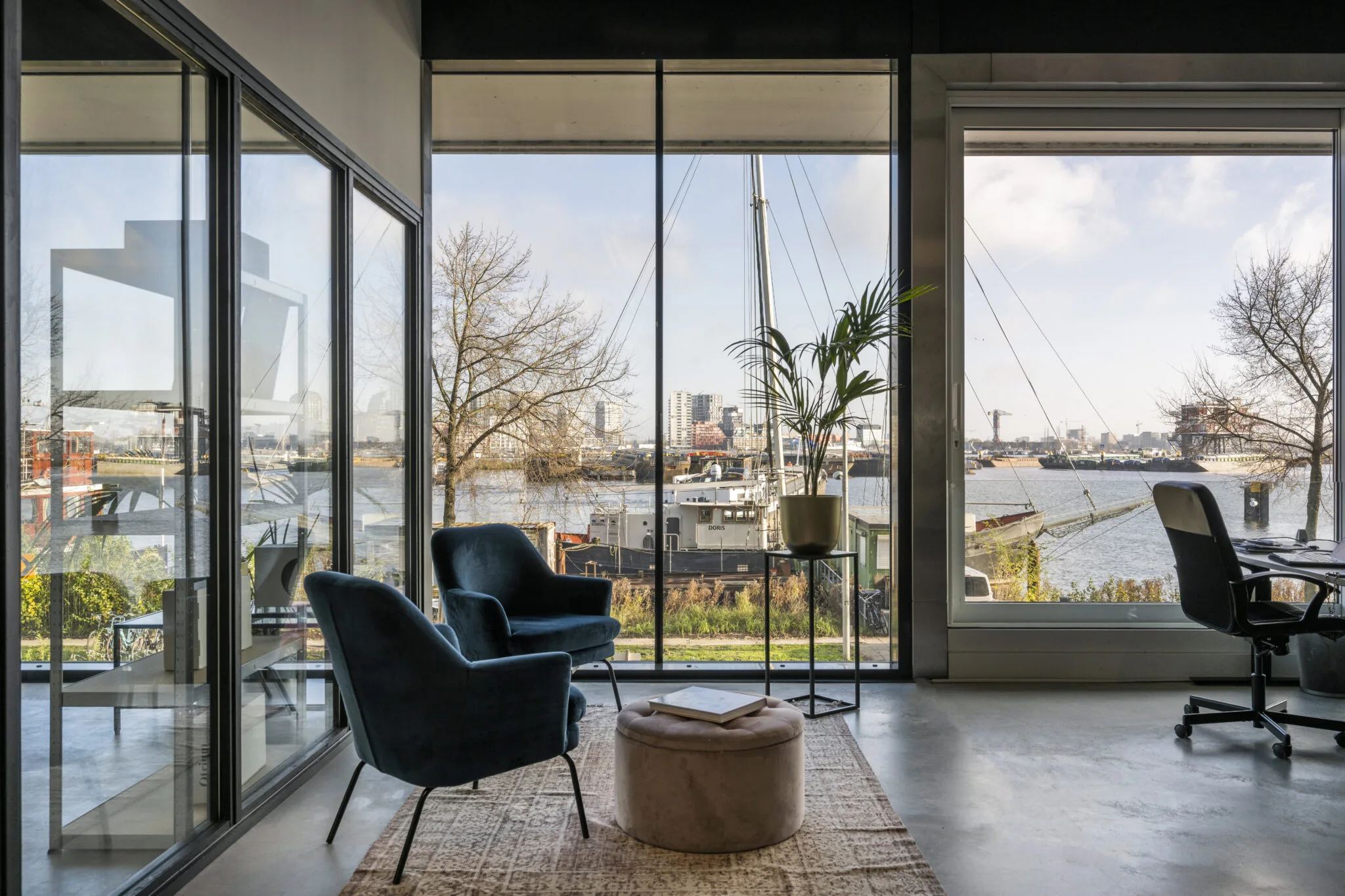 Modern interieur met uitzicht op het water en de haven bij de Danzigerkade in Amsterdam.