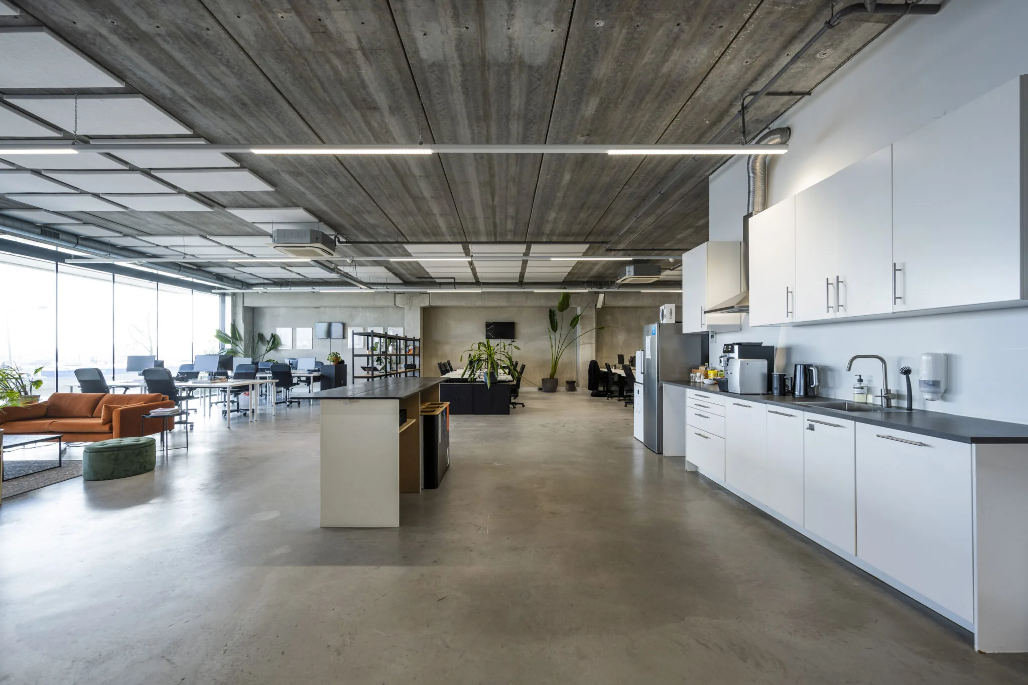 Moderne open kantoorruimte aan de Danzigerkade met keuken, werkplekken en loungehoek.