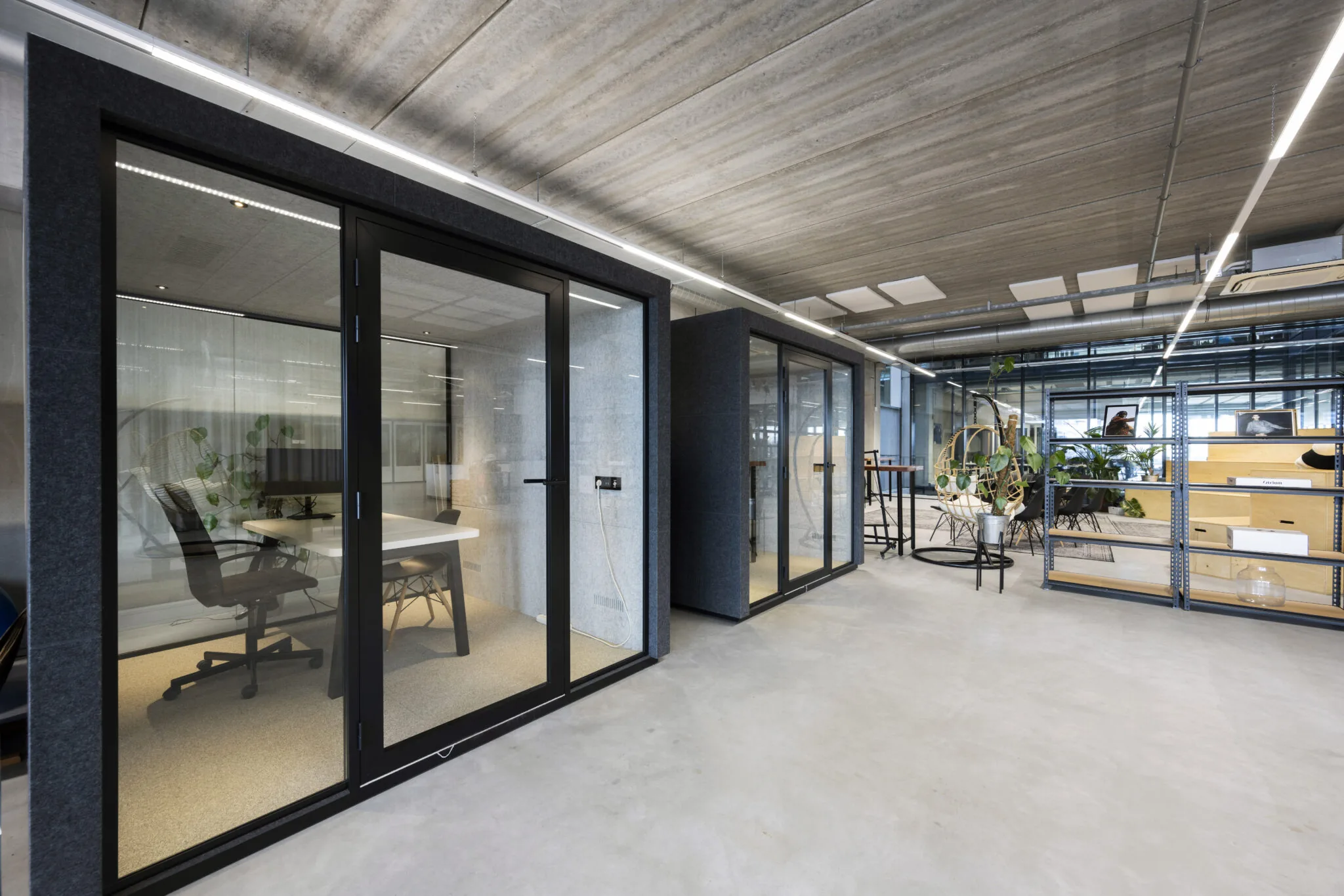 Modern kantoorinterieur op de Danzigerkade 33 met glazen vergaderruimtes en industriële afwerking.