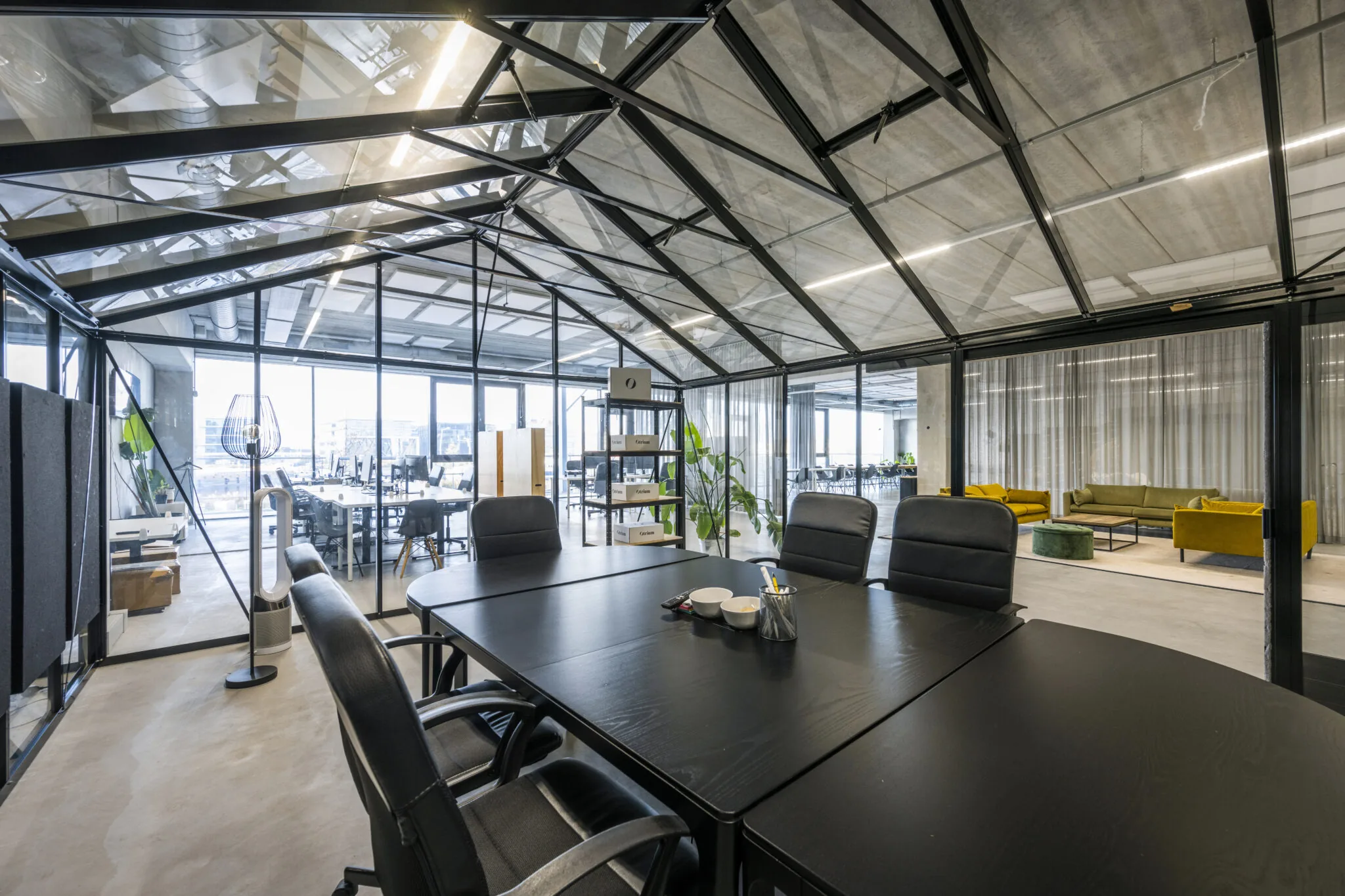 Moderne vergaderruimte in een glazen kasstructuur binnen een open kantoor aan de Danzigerkade, ontworpen door Paul Starink.