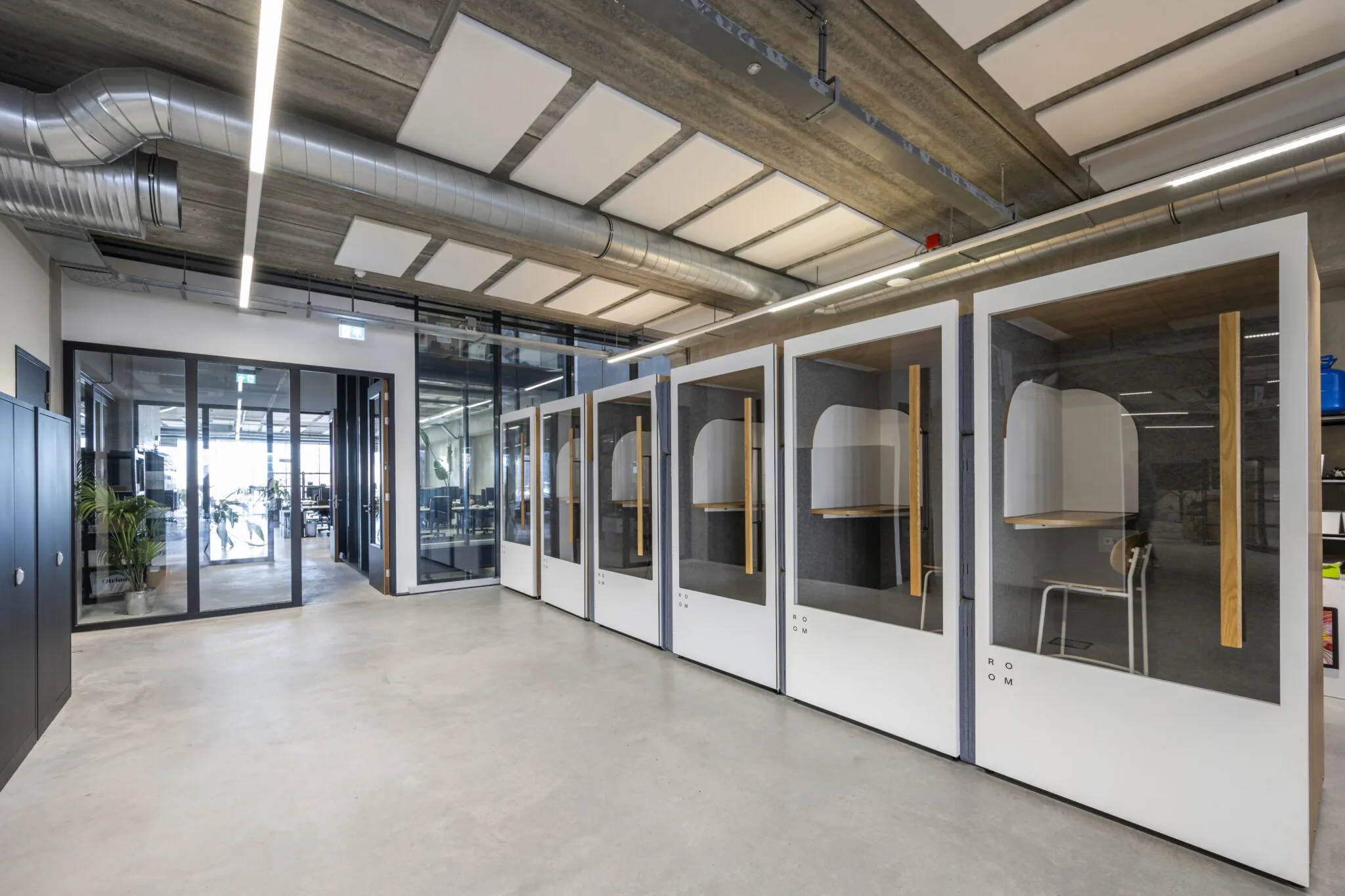 Moderne kantoorruimte aan de Danzigerkade met glazen belcellen en industriële afwerking.