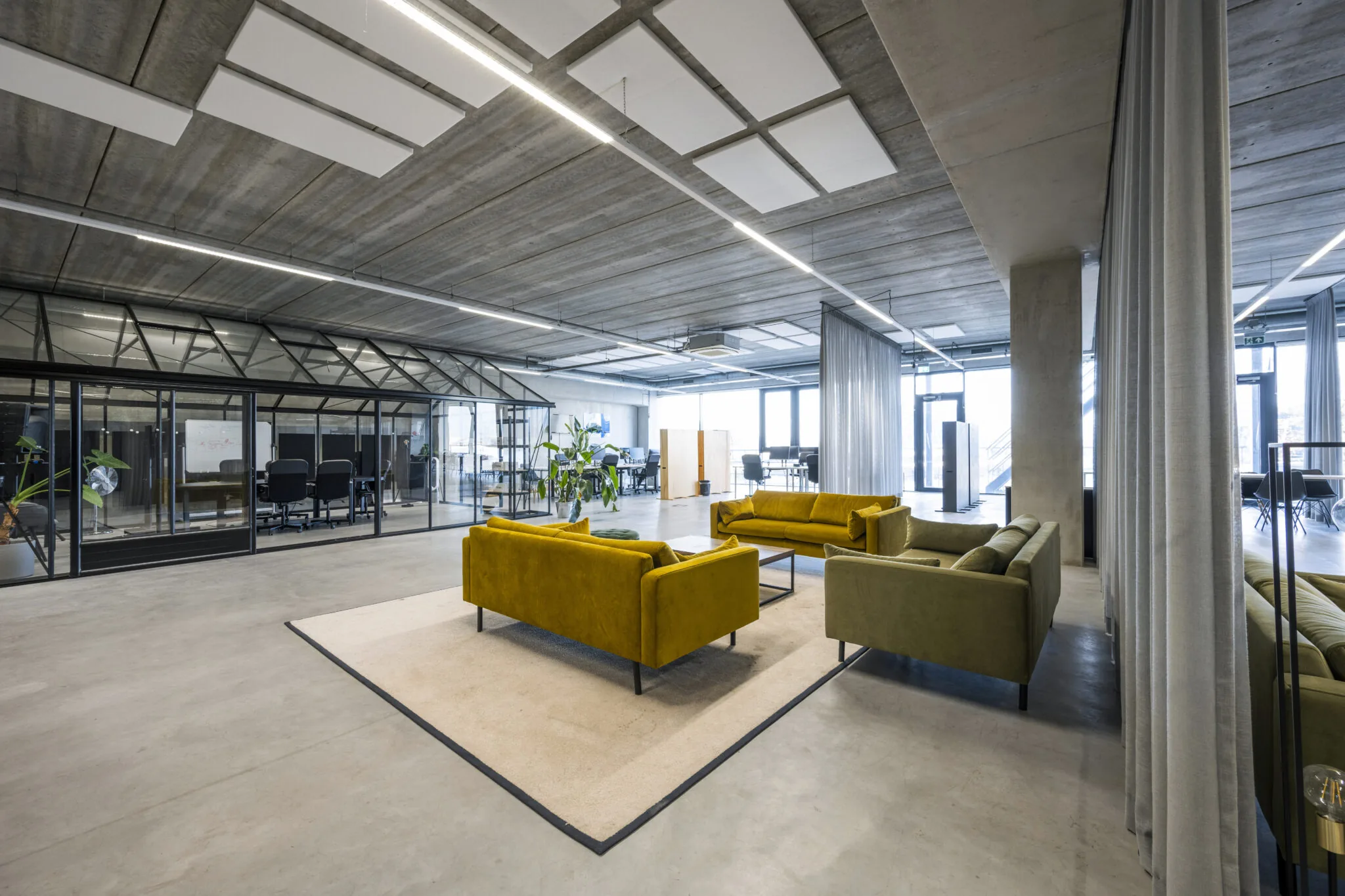 Moderne kantoorruimte aan de Danzigerkade met kleurrijke zithoek en glazen vergaderruimte.