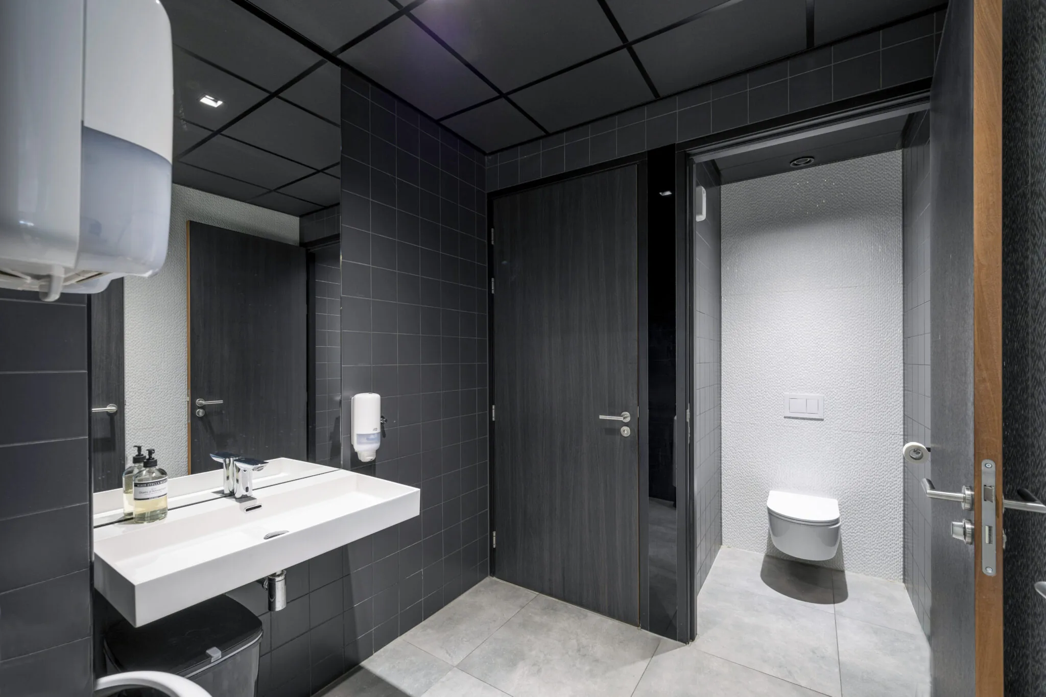 Moderne, strak afgewerkte toiletruimte met donkergrijze tegels in het pand aan de Danzigerkade 044.