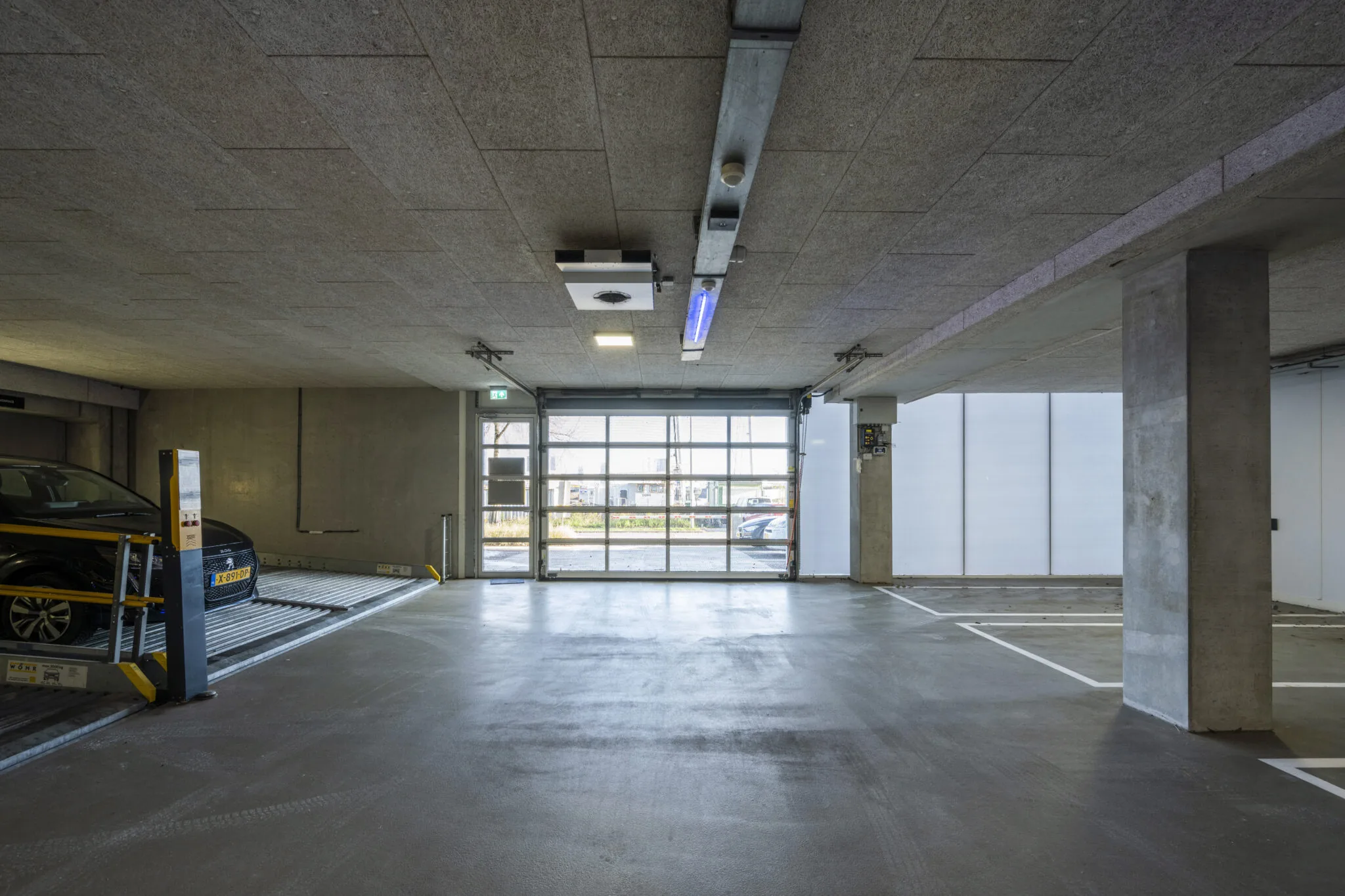 Ondergrondse parkeergarage aan de Danzigerkade met een autolift en betonnen afwerking.