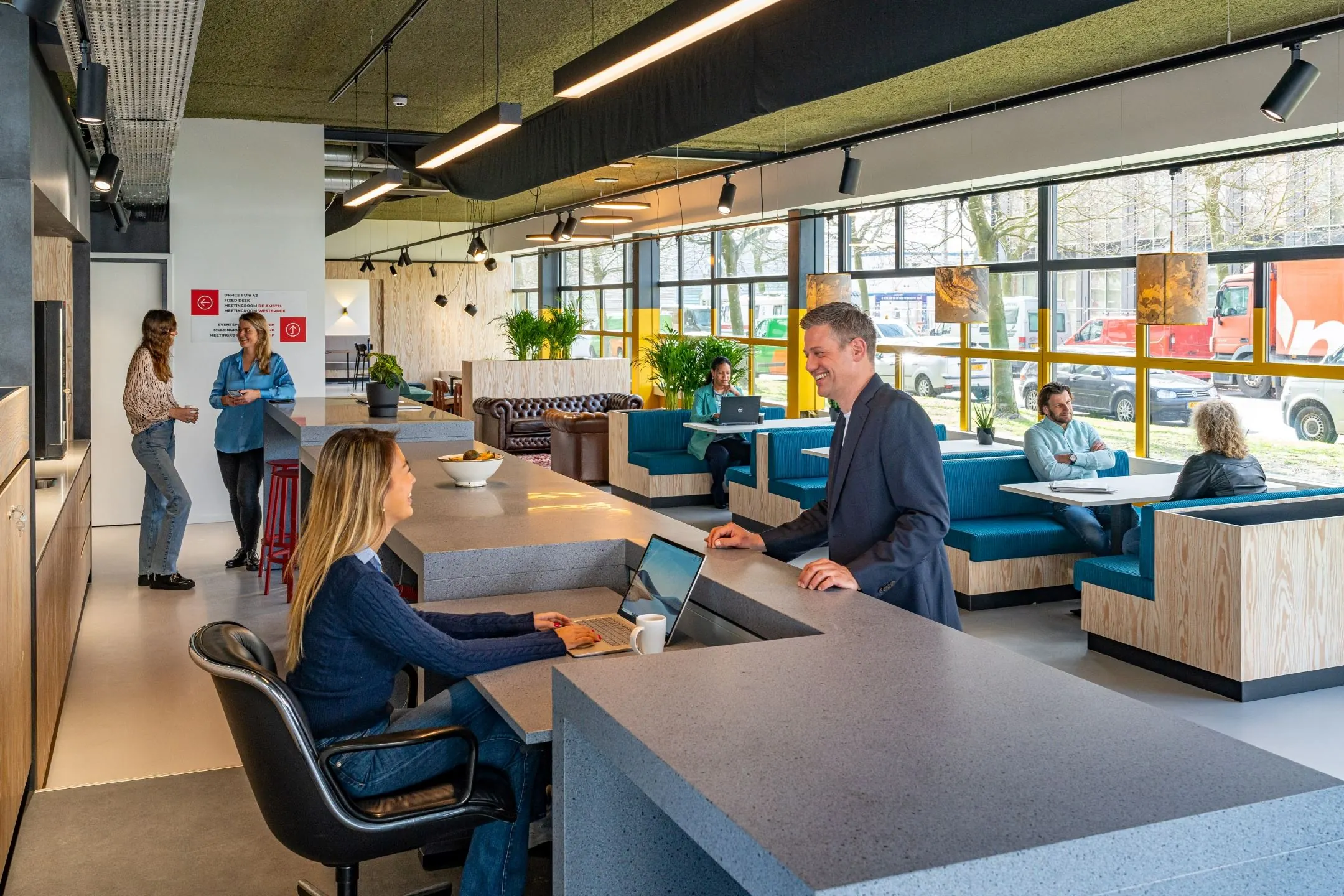 Moderne ontvangstruimte in een kantoorpand aan de Disketteweg 14 met werkende en overleggende mensen.