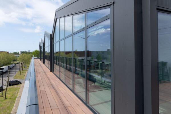 Modern bedrijfsgebouw aan de Disketteweg 14 met glazen gevel en houten dakterras.