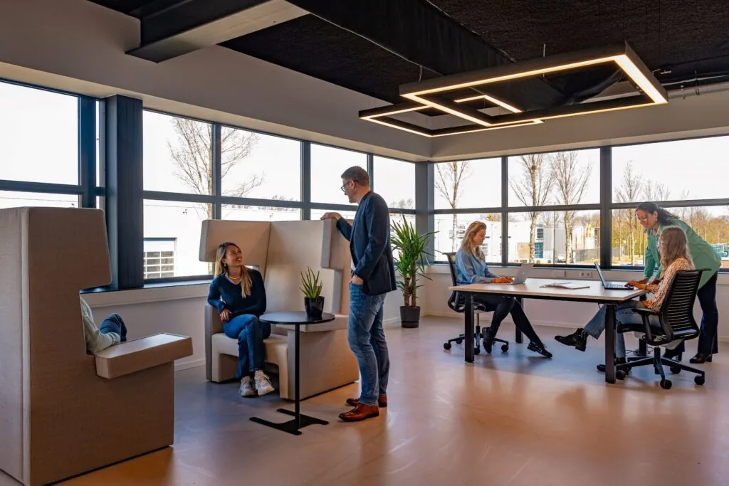 Moderne kantoorruimte aan de Disketteweg 14 met mensen in overleg en aan het werk achter laptops.