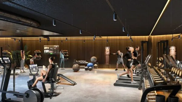 Moderne fitnessruimte van Entree 201 met sportende mensen op verschillende apparaten en trainingszones.