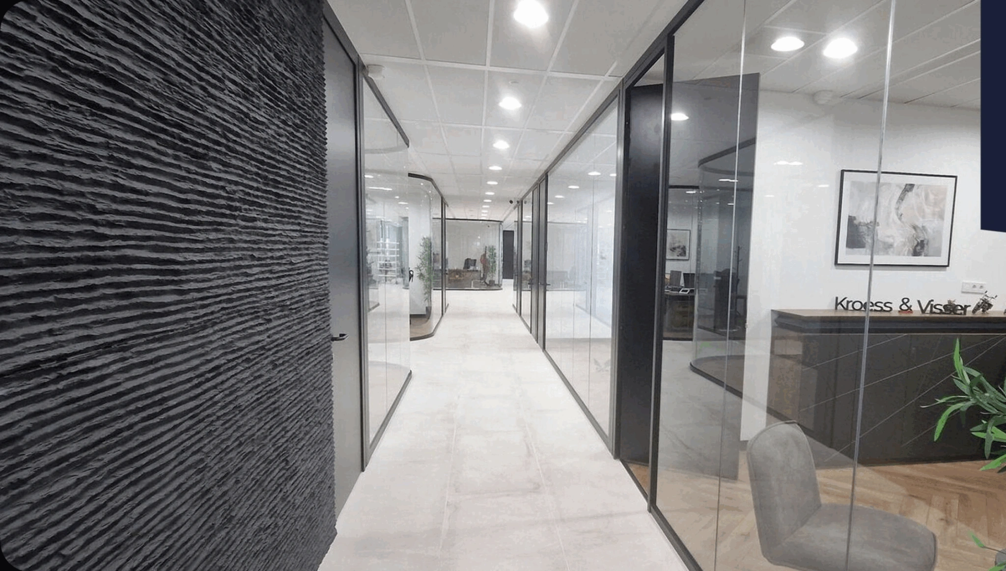 Moderne kantoorruimte met glazen wanden, een zwarte structuurwand en het logo van Kroes & Visser bij de receptie.
