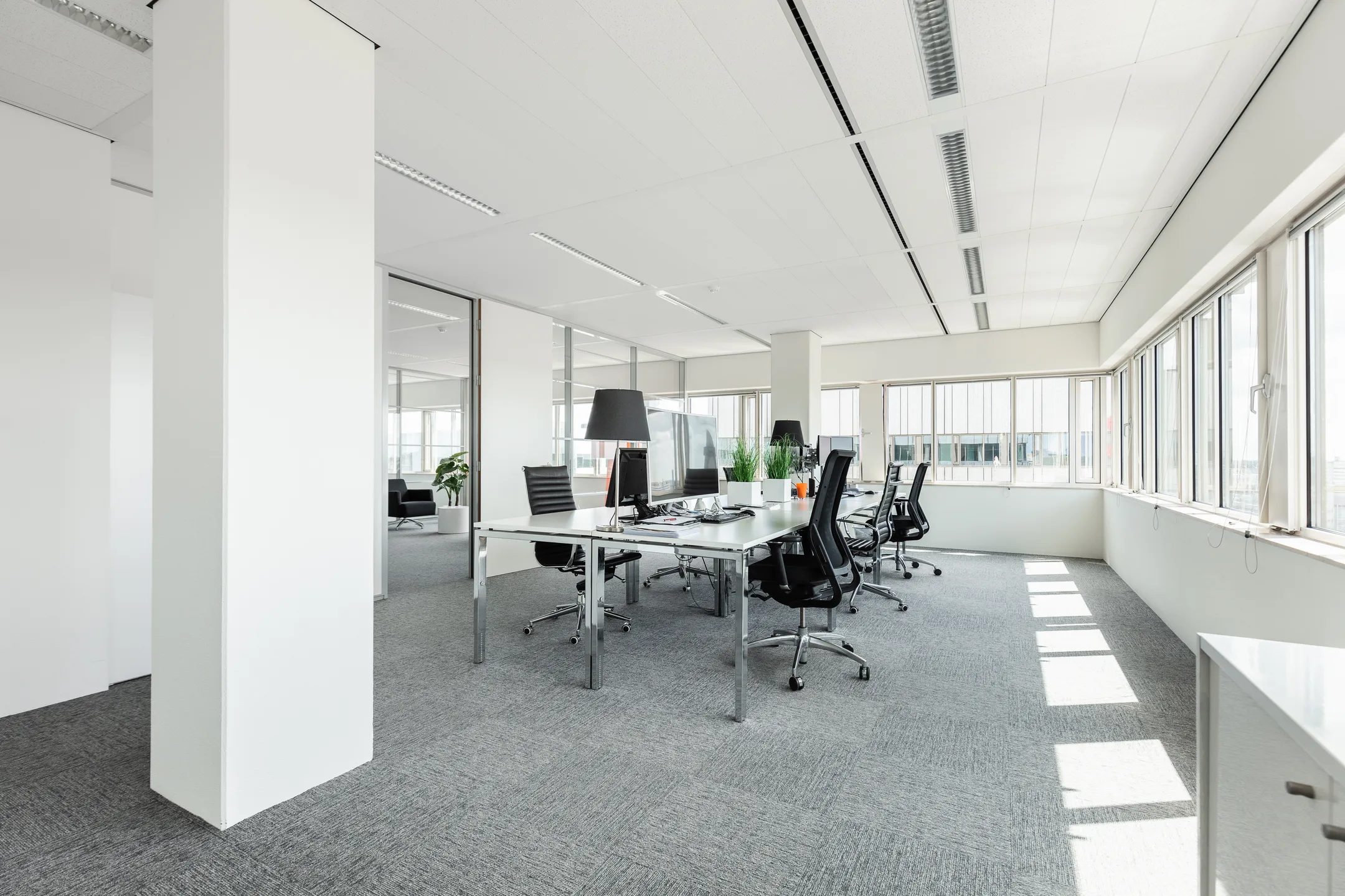Licht en modern kantoorinterieur met werkplekken aan de Herengracht 204.