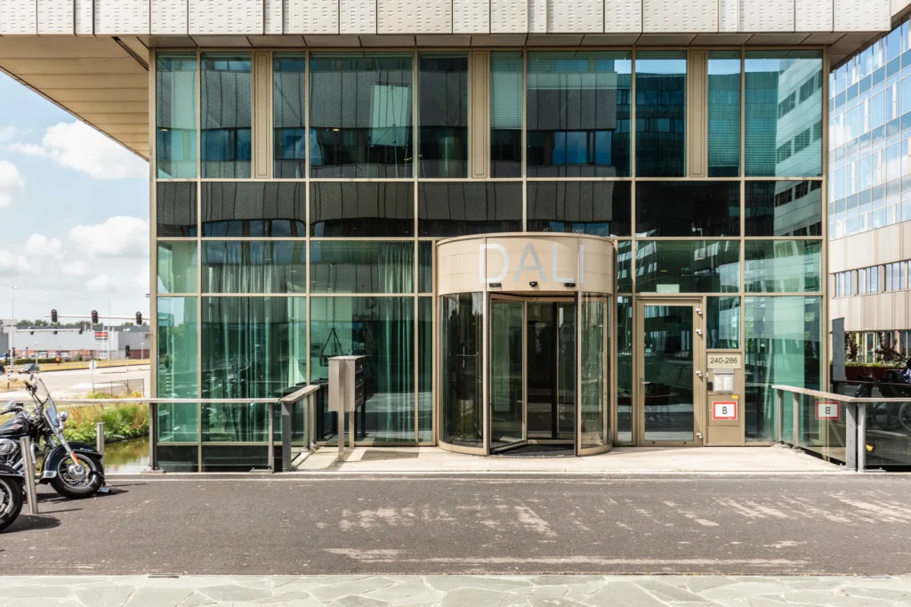 Glazen entree van kantoorgebouw DALI aan de Herengracht 204 met draaideur en adresbord.