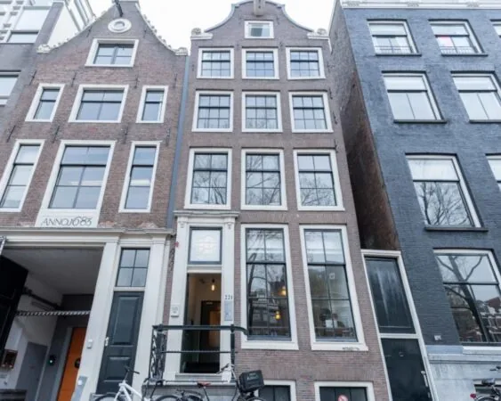 Voorgevel van het historische grachtenpand Herengracht 211 in Amsterdam met hoge ramen en trapgevel.