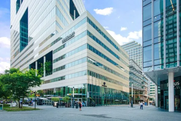 Modern kantoorgebouw Ito met omliggende hoogbouw en bedrijvige straat op de Zuidas in Amsterdam.