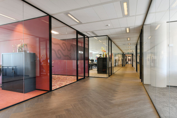 Gang van een modern kantoor met glazen wanden langs de Jachthavenweg.