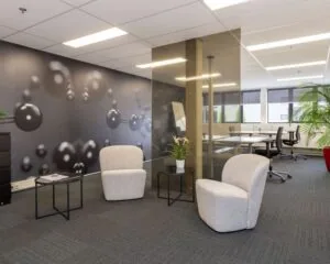 Moderne kantoorruimte aan de Droogdokstraat 1-5 met loungehoek, glazen vergaderruimte en decoratieve wand met molecuulprint.
