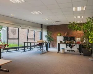 Ruime en moderne kantoorruimte te huur aan het Kennedyplein 18 met grote ramen, bureaus en veel natuurlijk licht.