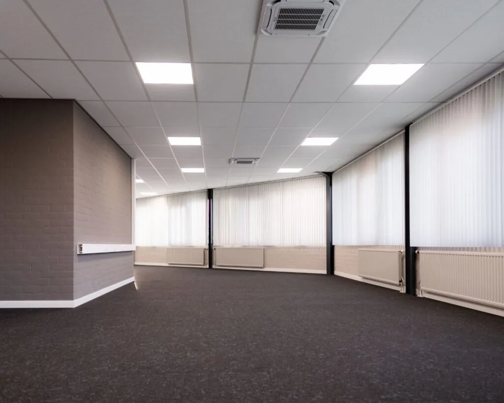 Lichte, lege kantoorruimte met systeemplafond en grote ramen aan de Parlevinkerweg 1-2.