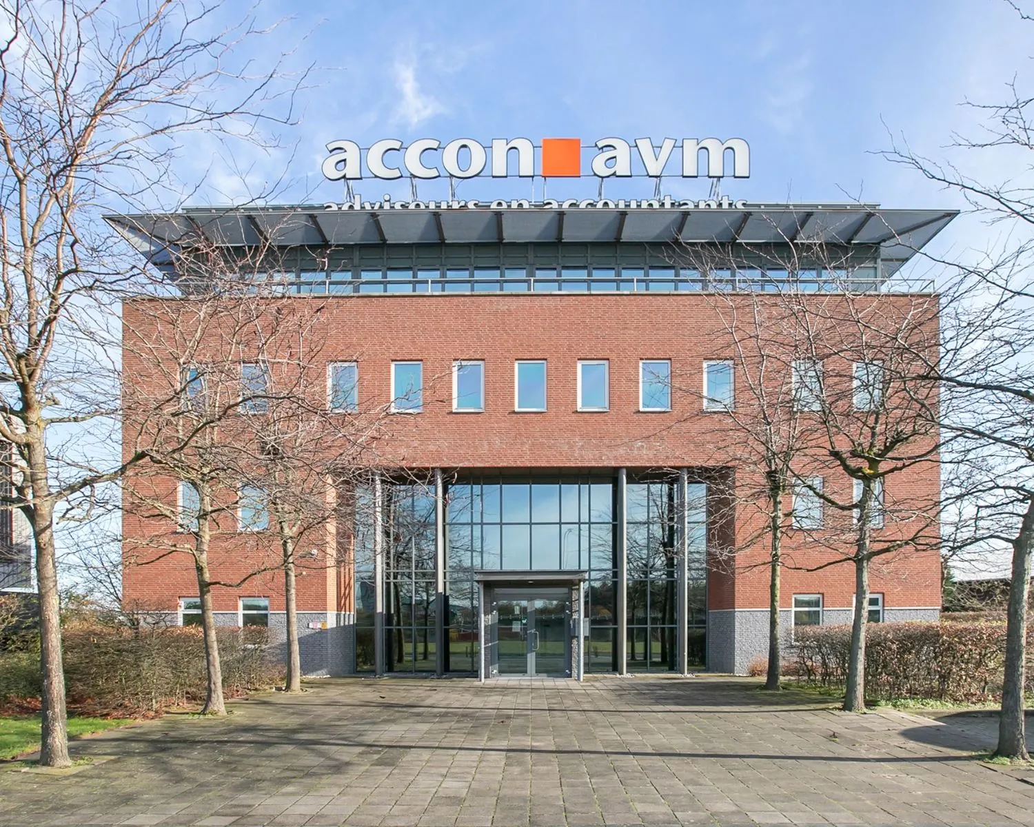 Vooraanzicht van het moderne kantoorpand aan de Venrayseweg 180 met het logo van Accon AVM op het dak.