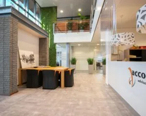 Moderne en lichte kantoorruimte aan de Venrayseweg 180 met een ontvangstruimte, vergadertafel en groene accenten.