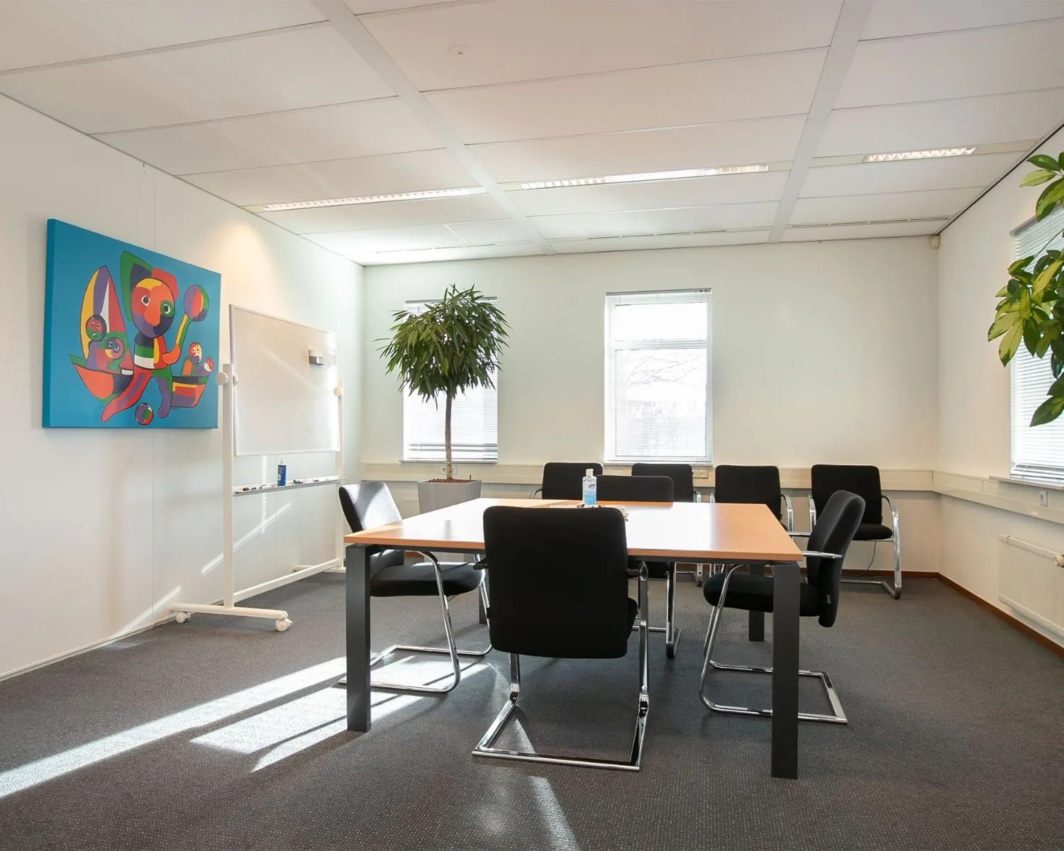 Vergaderruimte te huur aan de Venrayseweg 180 met moderne inrichting, grote tafel, zes stoelen en veel daglicht.
